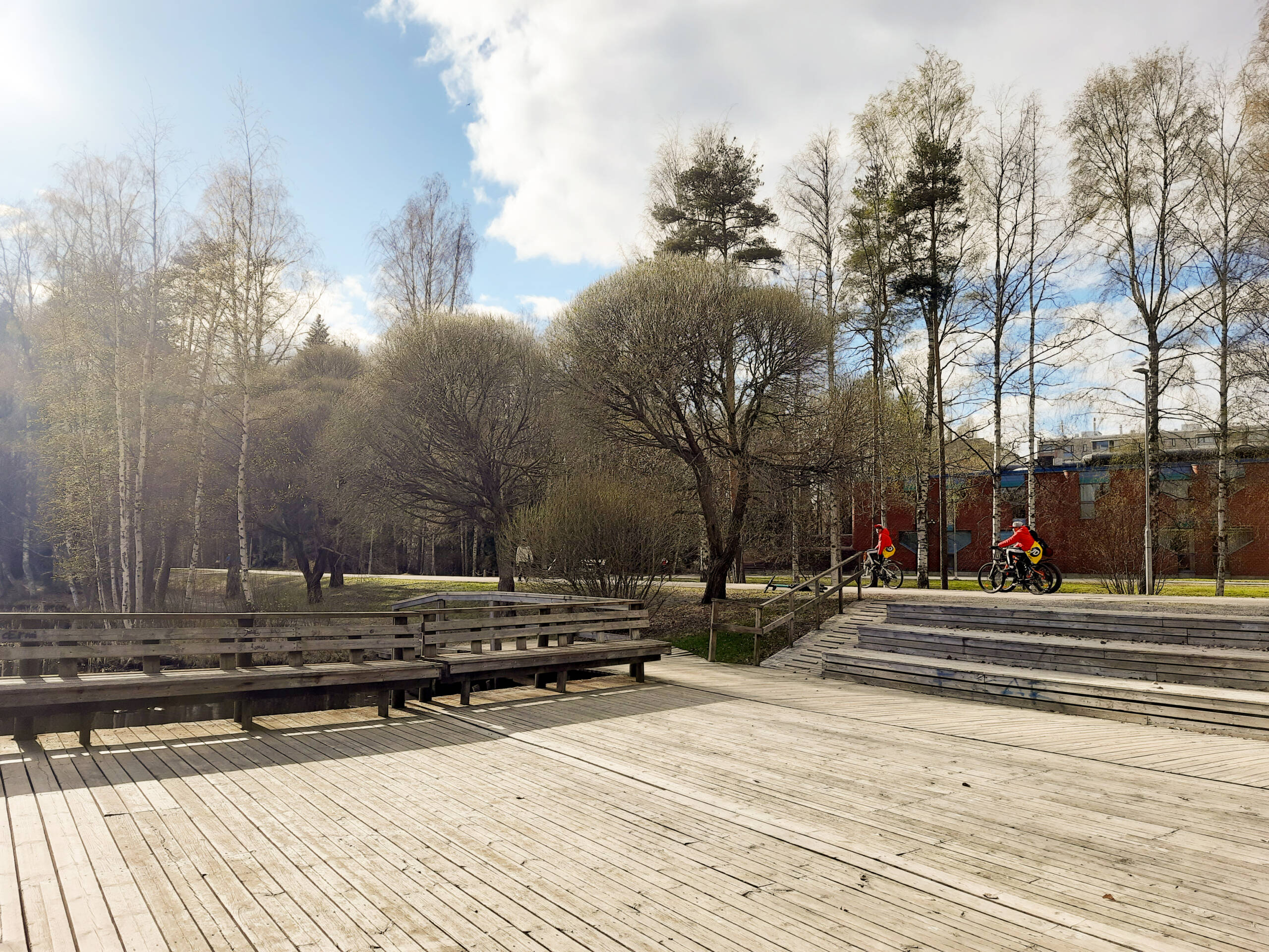 Park with wooden board walk and some seats.