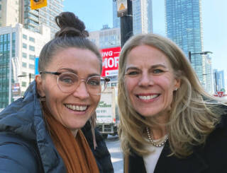 Two women smiling in streets of Toronto.
