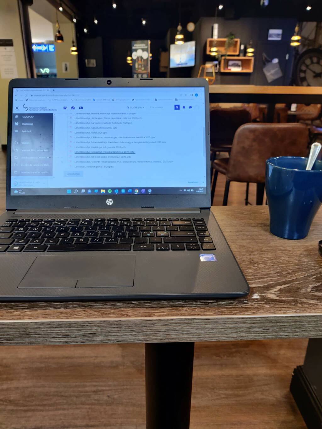 Pöydällä on kannettava tietokone kahvikupin vieressä.