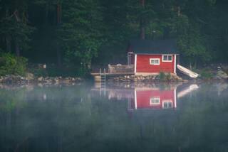 A picture of a cabin by lakeshore